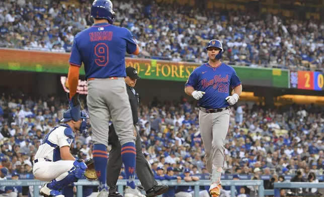 New York Mets' Pete Alonso, right, scores after hitting a two-run home run as Brandon Nimmo waits for him while Los Angeles Dodgers catcher Dalton Rushing kneels at the plate during the first inning of a baseball game Wednesday, June 4, 2025, in Los Angeles. (AP Photo/Mark J. Terrill)