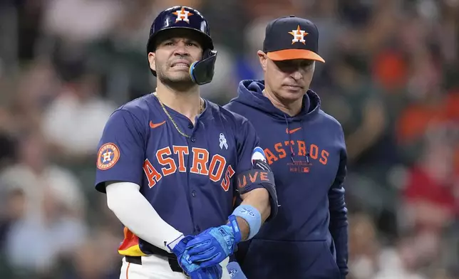 Houston Astros manager Joe Espada, right, walks with Jose Altuve after Altuve was hit by a pitch thrown by Minnesota Twins pitcher Louis Varland during the seventh inning of a baseball game Sunday, June 15, 2025, in Houston. (AP Photo/David J. Phillip)