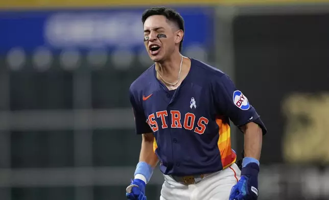 Houston Astros' Mauricio Dubón celebrates after hitting a game-winning RBI single against the Minnesota Twins during the 10th inning of a baseball game Sunday, June 15, 2025, in Houston. (AP Photo/David J. Phillip)