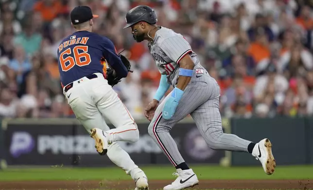 Houston Astros pitcher Shawn Dubin (66) reaches to tag out Minnesota Twins' Willi Castro during the eighth inning of a baseball game Sunday, June 15, 2025, in Houston. (AP Photo/David J. Phillip)