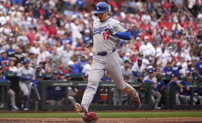 Los Angeles Dodgers' Shohei Ohtani scores on a wild pitch by St. Louis Cardinals pitcher Ryan Helsley during the ninth inning of a baseball game Saturday, June 7, 2025, in St. Louis. (AP Photo/Jeff Roberson)