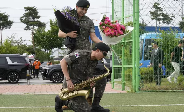 K-pop band BTS members RM, bottom, and V react after being discharged from a mandatory military service in Chuncheon, South Korea, Tuesday, June 10, 2025. (AP Photo/Ahn Young-joon)