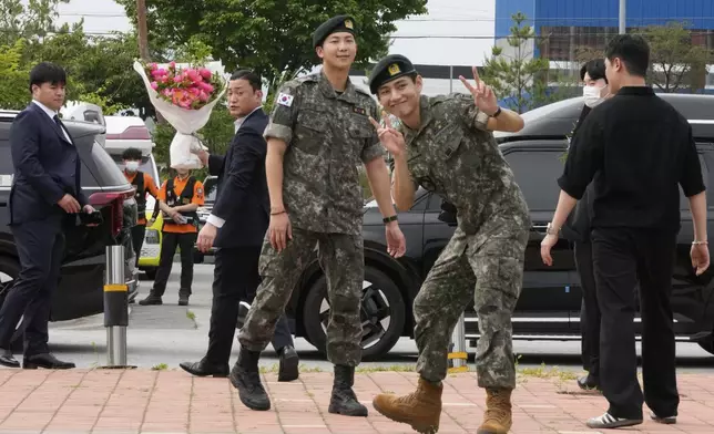 K-pop band BTS members RM, center left, and V, center right, react after being discharged from a mandatory military service in Chuncheon, South Korea, Tuesday, June 10, 2025. (AP Photo/Ahn Young-joon)