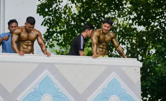 Contestants prepare at backstage during their bodybuilding competition to mark International Olympic Day at the Myanmar Convention Center in Yangon, Myanmar, Saturday, June 28, 2025. (AP Photo/Thein Zaw)