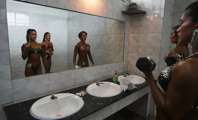 Female contestants prepare at backstage before their model physique competition to mark International Olympic Day at the Myanmar Convention Center in Yangon, Myanmar, Saturday, June 28, 2025. (AP Photo/Thein Zaw)