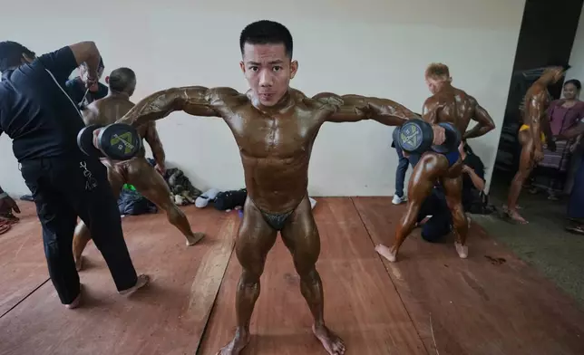 Contestants prepare at backstage during their bodybuilding competition to mark International Olympic Day at the Myanmar Convention Center in Yangon, Myanmar, Saturday, June 28, 2025. (AP Photo/Thein Zaw)