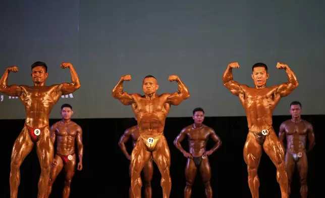 Contestants compete during their bodybuilding competition to mark International Olympic Day at the Myanmar Convention Center in Yangon, Myanmar, Saturday, June 28, 2025. (AP Photo/Thein Zaw)