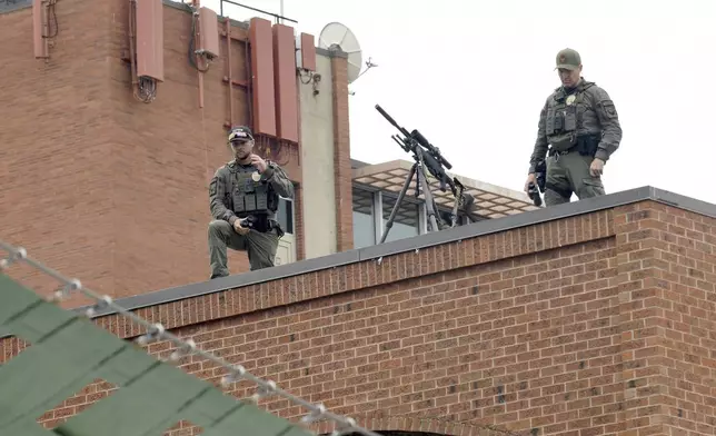 Law enforcement officers keep watch from a rooftop overlooking the Boulder Jewish Festival in Boulder, Colo., on Sunday, June 8, 2025. (AP Photo/Thomas Peipert)