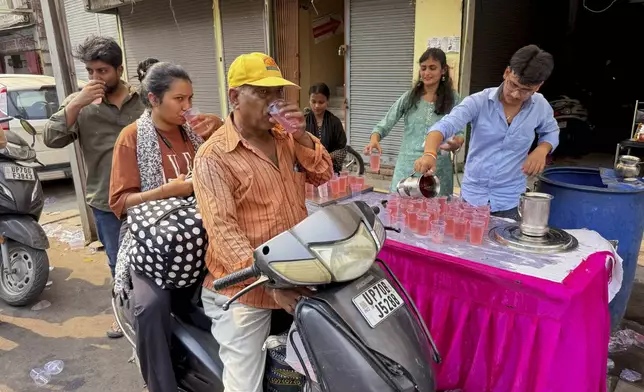Motorists stop for a free roadside drink on a hot summer day in Prayagraj in the northern state of Uttar Pradesh, India, Tuesday, June 10, 2025. (AP Photo/Rajesh Kumar Singh)