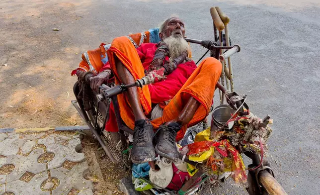 An elderly man rests on his tricycle cart on a hot summer day in Prayagraj in the northern state of Uttar Pradesh, India, Tuesday, June 10, 2025. (AP Photo/Rajesh Kumar Singh)