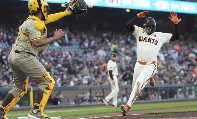 San Diego Padres catcher Elias Díaz, left, forces San Francisco Giants' Willy Adames out at home during the second inning of a baseball game in San Francisco, Monday, June 2, 2025. (AP Photo/Jeff Chiu)