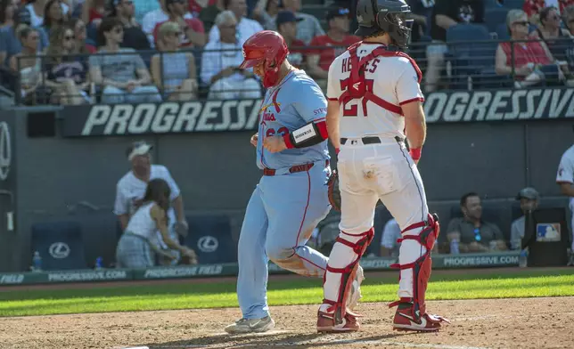 St. Louis Cardinals' St. Louis Cardinals' Yohel Pozo, left, scores on a sacrifice fly by Brendan Donovan as Cleveland Guardians' Austin Hedges stands by during the sixth inning of a baseball game, Saturday, June 28, 2025, in Cleveland. (AP Photo/Phil Long)