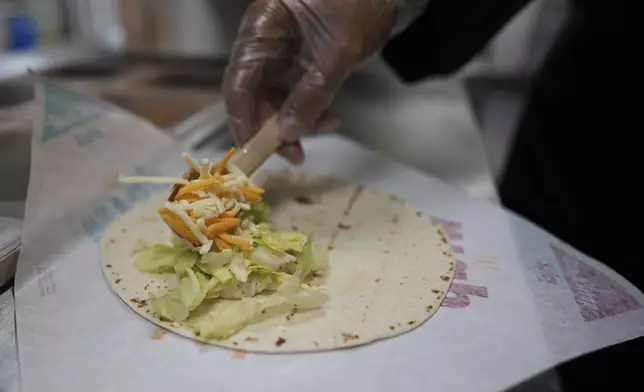 Charles L. Krumsiek, a McDonald's chef, puts cheese on a tortilla to make a snack wrap at McDonald's Headquarter in Chicago, Thursday, May 29, 2025. (AP Photo/Nam Y. Huh)