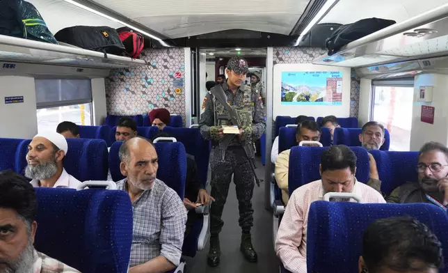An armed commando inspects tickets inside Vande Bharat Express train soon to be inaugurated to run between Srinagar and Katra, in Srinagar, Indian controlled Kashmir, Friday, June 6, 2025. (AP Photo/Dar Yasin)