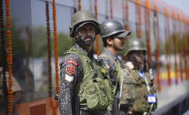 Security personnel stand guard next to Vande Bharat Express train which is soon to be inaugurated to run between Srinagar and Katra, in Srinagar, Indian controlled Kashmir, Friday, June 6, 2025. (AP Photo/Dar Yasin)