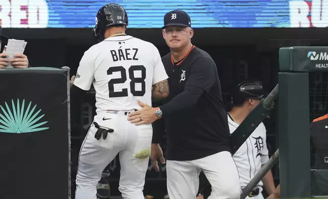 Detroit Tigers manager A.J. Hinch, right, congratulates Javier B·ez (28) after he scored against the Chicago Cubs in the fifth inning during a baseball game, Friday, June 6, 2025, in Detroit. (AP Photo/Paul Sancya)