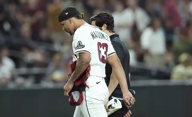 Arizona Diamondbacks pitcher Justin Martinez leaves the game due to injury during the ninth inning of a baseball game against the Seattle Mariners Monday, June 9, 2025, in Phoenix. (AP Photo/Ross D. Franklin)