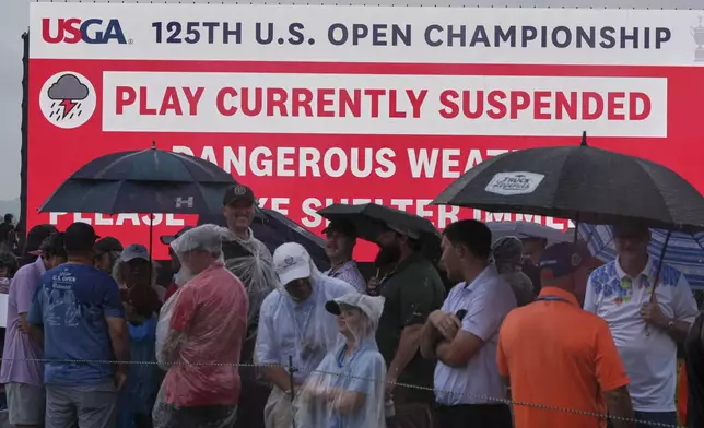Fans wait out a weather delay in the final round of the U.S. Open golf tournament at Oakmont Country Club Sunday, June 15, 2025, in Oakmont, Pa. (AP Photo/Seth Wenig)