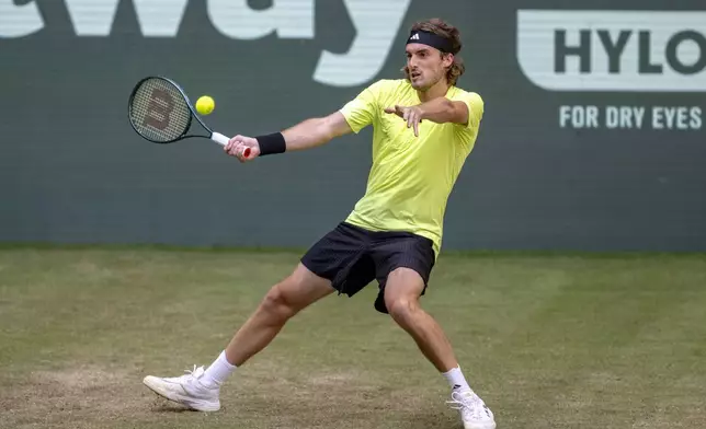 Greece's Stefanos Tsitsipas returns the ball to USA's Alex Michelsen during the Halle ATP tennis tournament in Halle, Germany, Wednesday, June 18, 2025. (David Inderlied/dpa via AP)