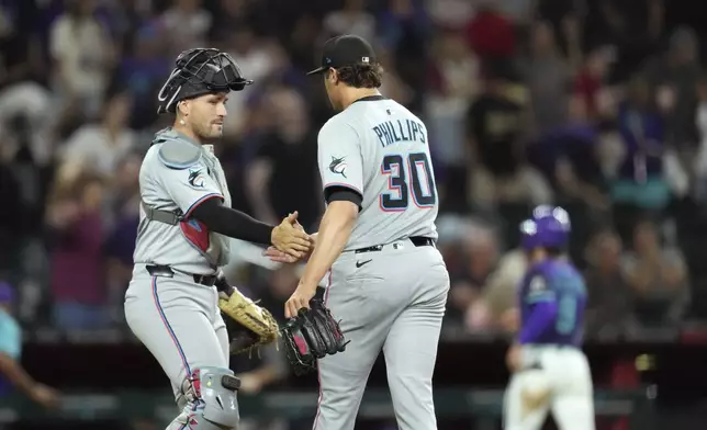 Miami Marlins pitcher Tyler Phillips (30) celebrates a win against the Arizona Diamondbacks with Marlins catcher Nick Fortes, left, after the final out during the ninth inning of a baseball game Friday, June 27, 2025, in Phoenix. (AP Photo/Ross D. Franklin)