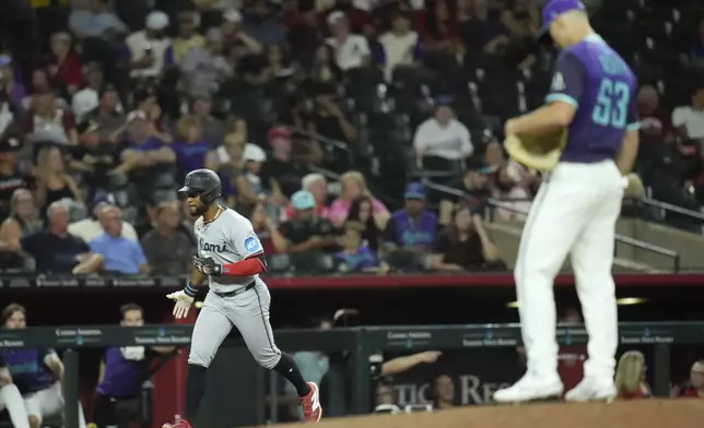 Miami Marlins' Otto Lopez, left, rounds the bases after hitting a two-run home run against Arizona Diamondbacks pitcher Tayler Scott during the ninth inning of a baseball game Friday, June 27, 2025, in Phoenix. (AP Photo/Ross D. Franklin)