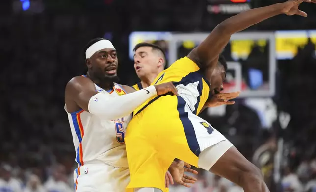 Oklahoma City Thunder guard Luguentz Dort, left, fouls Indiana Pacers center Thomas Bryant (3) during the second half of Game 1 of the NBA Finals basketball series Thursday, June 5, 2025, in Oklahoma City. (AP Photo/Julio Cortez)