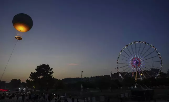The helium ballon that was used during the 2024 Olympic Games as the Olympic cauldron is launched in the Tuileries Gardens of Paris on Saturday, June 21, 2025. (AP Photo/Aurelien Morissard)