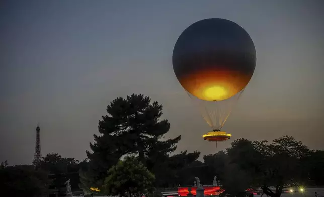 The helium ballon that was used during the 2024 Olympic Games as the Olympic cauldron is launched in the Tuileries Gardens of Paris on Saturday, June 21, 2025, with the Eiffel Tower in the background. (AP Photo/Aurelien Morissard)