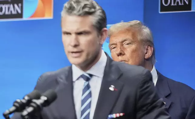 President Donald Trump watches Defense Secretary Pete Hegseth during a press conference after the plenary session at the NATO summit in The Hague, Netherlands, Wednesday, June 25, 2025. (AP Photo/Markus Schreiber)