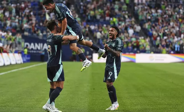 Seattle Sounders forward Danny Musovski, left, is greeted by midfielder Kalani Kossa-Rienzi, center, and forward Jesús Ferreira, right, after scoring against Austin FC during the second half of an MLS soccer match Saturday, June 28, 2025, in Seattle. (AP Photo/Lindsey Wasson)