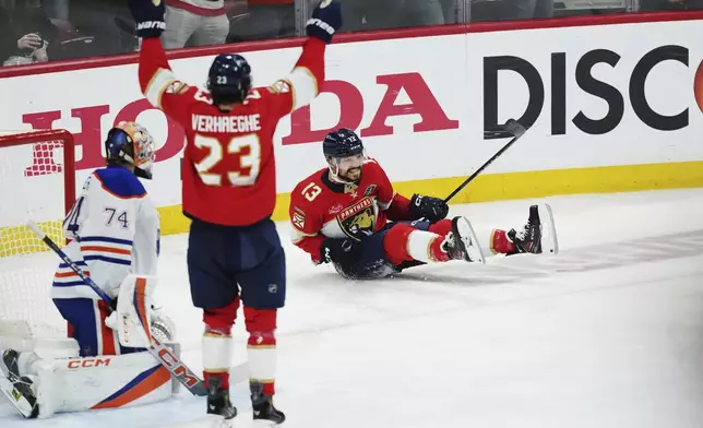 Florida Panthers' Sam Reinhart (13) celebrates his goal against Edmonton Oilers goalie Stuart Skinner (74) as Panthers' Carter Verhaeghe (23) reacts during the first period in Game 6 of the NHL hockey Stanley Cup Final in Sunrise, Fla., Tuesday, June 17, 2025. (Nathan Denette/The Canadian Press via AP)