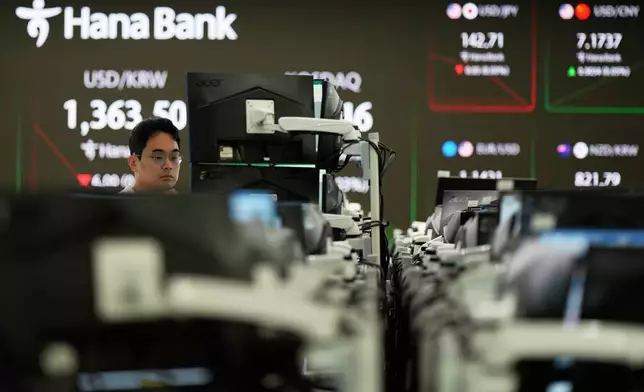 A dealer watches computer monitors near the screens showing the foreign exchange rate between U.S. dollar and South Korean won at a dealing room of Hana Bank in Seoul, South Korea, Thursday, June 5, 2025. (AP Photo/Lee Jin-man)