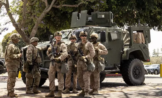 Members of the California National Guard and U.S. Marines, guard the entrance outside the Wilshire Federal Building, ahead of Saturday's nationwide "No Kings Day" protest, in Los Angeles, Calif., Friday, June 13, 2025. (Stephen Lam/San Francisco Chronicle via AP)