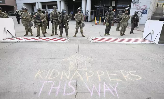 Law enforcement stand guard outside the Federal Building during a protest on Friday, June 13, 2025, in Los Angeles. (AP Photo/Wally Skalij)
