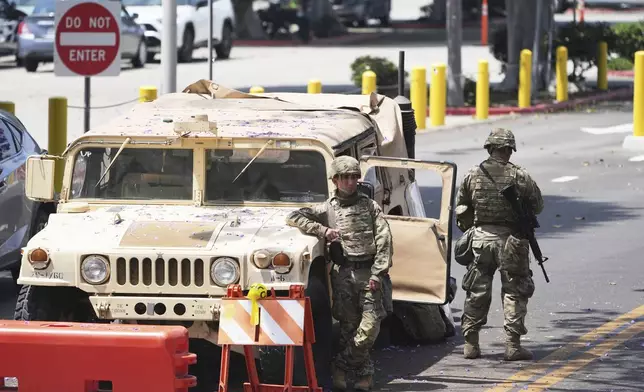 Members of the California National Guard work outside of a federal building Friday, June 13, 2025, in Los Angeles (AP Photo/Damian Dovarganes)