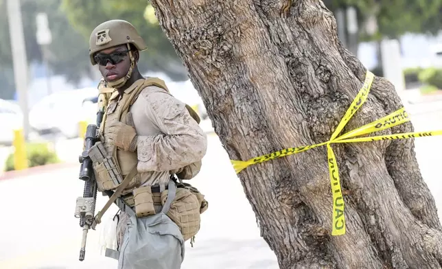 A U.S Marine works outside of a federal building Friday, June 13, 2025, in Los Angeles (AP Photo/Noah Berger)