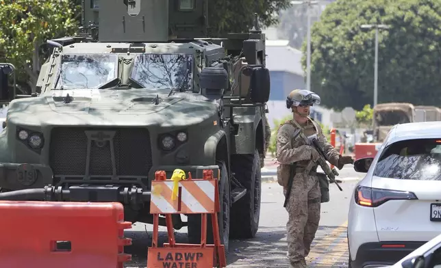 A U.S Marine works a checkpoint outside of a federal building, Friday, June 13, 2025, in Los Angeles (AP Photo/Damian Dovarganes)