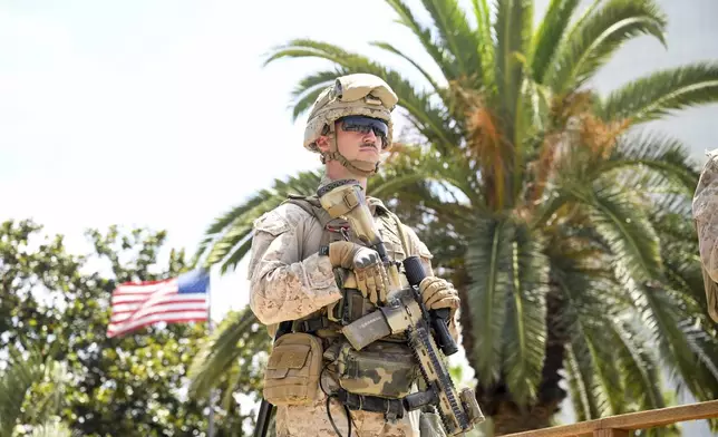 A U.S Marine guards a federal building, Friday, June 13, 2025, in Los Angeles (AP Photo/Noah Berger)
