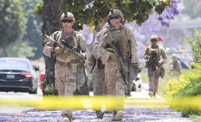 U.S Marines work outside of a federal building, Friday, June 13, 2025, in Los Angeles (AP Photo/Damian Dovarganes)