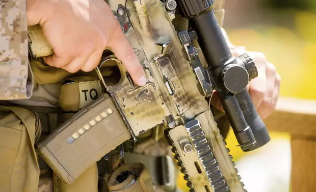 A U.S Marine holds a rifle outside of a federal building, Friday, June 13, 2025, in Los Angeles (AP Photo/Noah Berger)