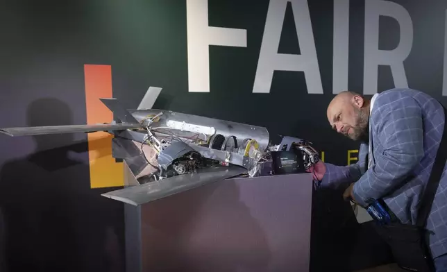 A visitor examines a damaged drone made by Russia with western components during the International Conference on Expanding Sanctions Against Russia in Kyiv, Ukraine, Friday, June 27, 2025. (AP Photo/Efrem Lukatsky)