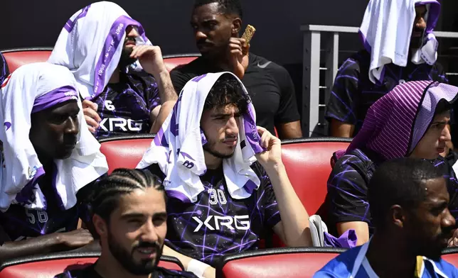 Al Ain's Hazim Abbas, center, shields himself from the sun with other players before the Club World Cup Group G soccer match between Wydad AC and Al Ain FC in Washington, Thursday, June 26, 2025. (AP Photo/Nick Wass)