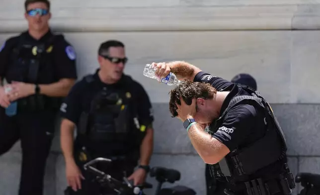 A U.S. Capitol Police officer pours water on his head Wednesday, June 25, 2025, outside the Capitol in Washington. (AP Photo/Julia Demaree Nikhinson)