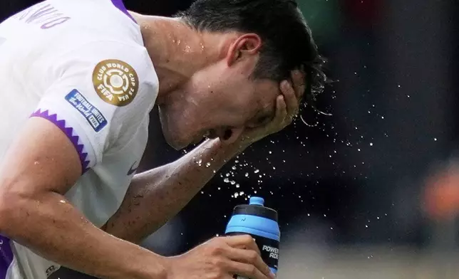 Al Ain's Park Yong-woo splashes his face to cool off during the Club World Cup Group G soccer match between Wydad AC and Al Ain FC in Washington, Thursday, June 26, 2025. (AP Photo/Julia Demaree Nikhinson)