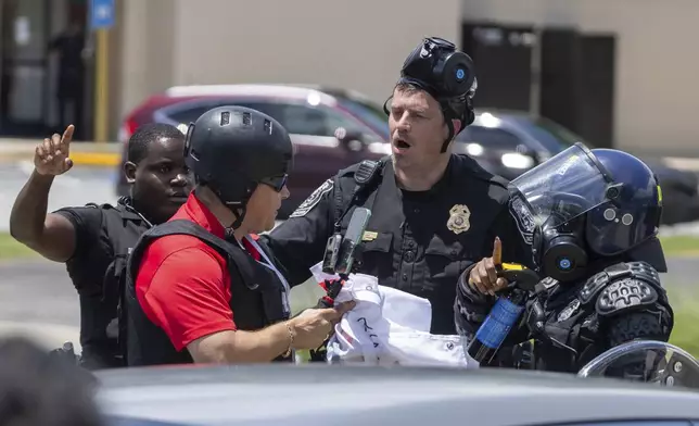 Police tell Spanish-language reporter Mario Guevara to move back during a protest on ICE raids and deportation arrests on Chamblee Tucker Road in Atlanta on Saturday, June 14, 2025. (Arvin Temkar/Atlanta Journal-Constitution via AP)