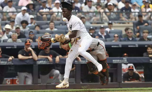 New York Yankees' Jazz Chisholm Jr. collides with Baltimore Orioles catcher Maverick Handley while running to home plate on a single hit by DJ LeMahieu during the second inning of a baseball game Sunday, June 22, 2025, in New York. (AP Photo/Pamela Smith)