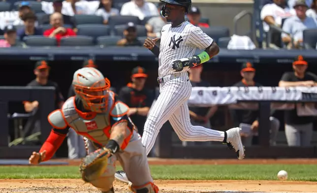 New York Yankees Jazz Chisholm Jr. scores a run in front of Baltimore Orioles catcher Gary Sánchez during the third inning of a baseball game, Saturday, June 21, 2025, in New York. (AP Photo/Noah K. Murray)