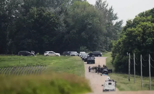 Members of law enforcement agencies investigate near a vehicle suspected to belong to shooting suspect, Vance Boelter, Sunday, June 15, 2025, in Belle Plaine, Minn. (AP Photo/George Walker IV)