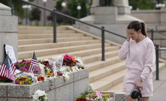 Leah Palmer visits a makeshift memorial for Minnesota state Rep. Melissa Hortman and her husband Mark at the state Capitol, Sunday, June 15, 2025, in St. Paul, Minn. (AP Photo/George Walker IV)