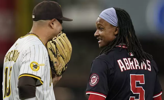 Washington Nationals' CJ Abrams (5) jokes with San Diego Padres third base Manny Machado during the fifth inning of a baseball game Tuesday, June 24, 2025, in San Diego. (AP Photo/Gregory Bull)